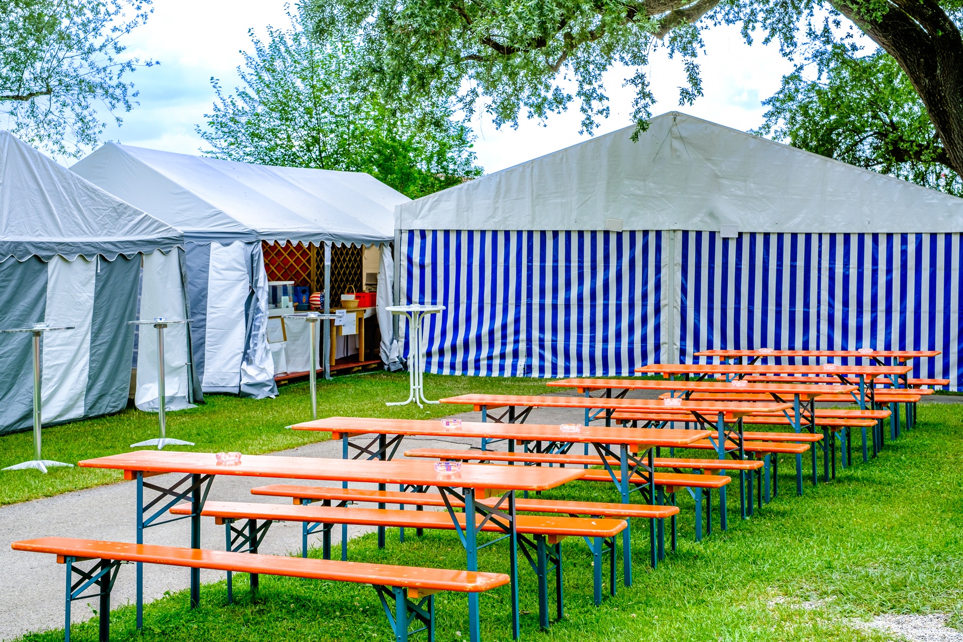Aufgestellte Baenke vor Festzelt auf Wiese | Bierzeltgarnitur